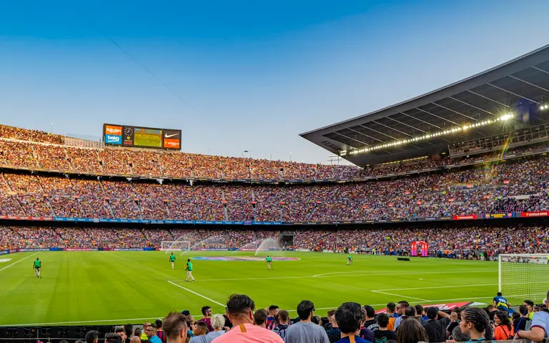 Prepun stadion pod vedrim nebom tokom utakmice, tribine krcate navijačima